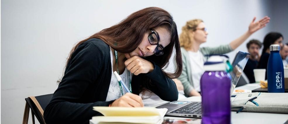 Women writing on notepad in classroom